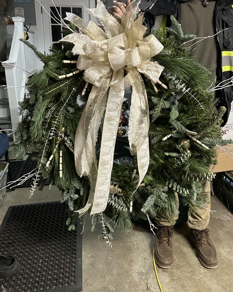 Fresh evergreen Christmas wreath with a large champagne ribbon bow